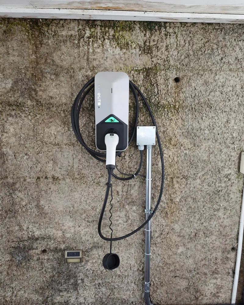 Cargador Livoltek con caja de conexión y tubo metálico EMT en un muro de hormigón